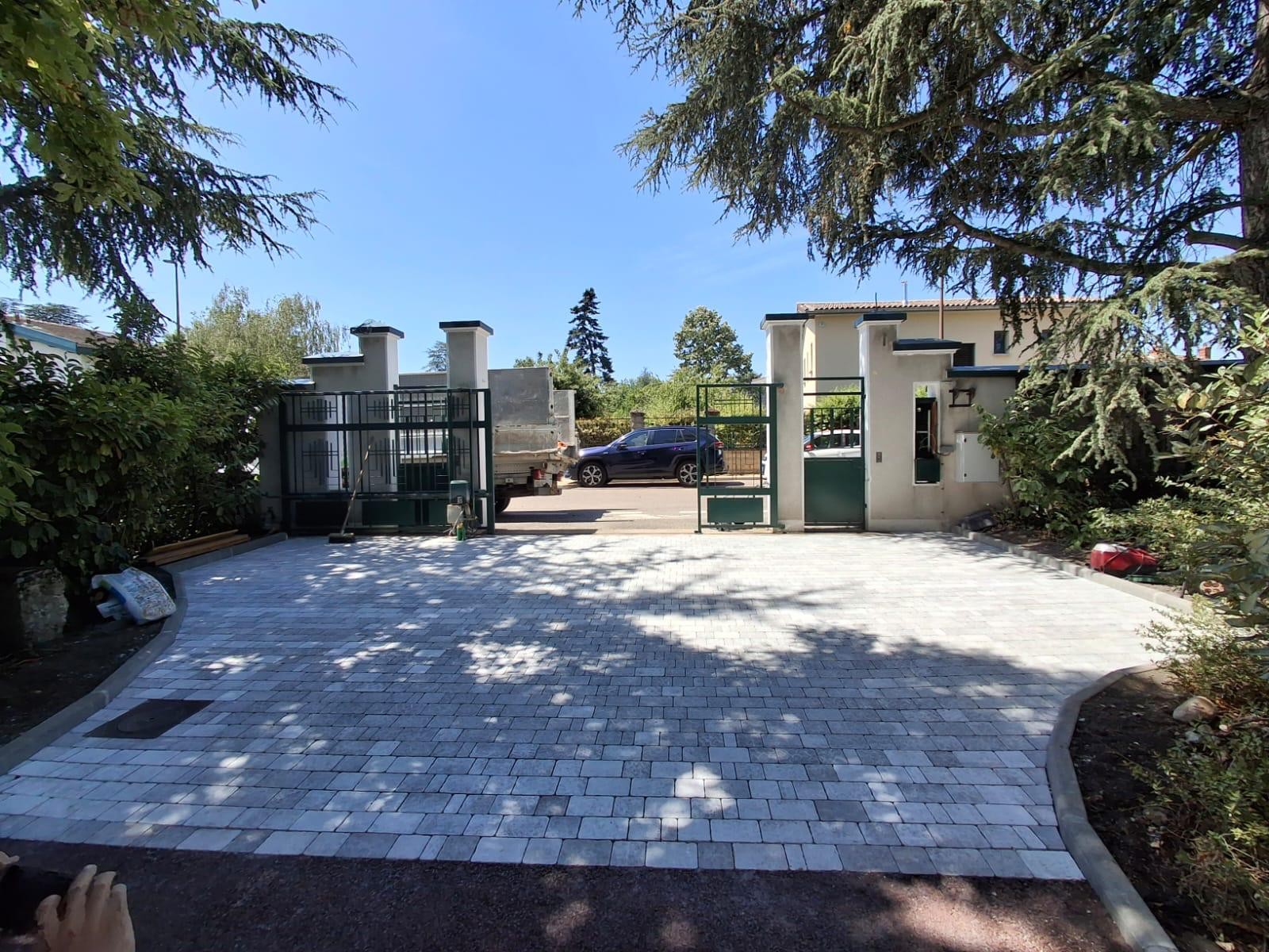 Cour pavée réalisée devant une maison contemporaine