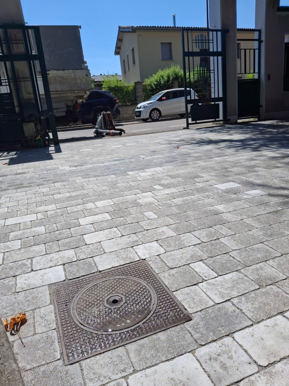 Cour pavée avec regard de visite intégré au revêtement