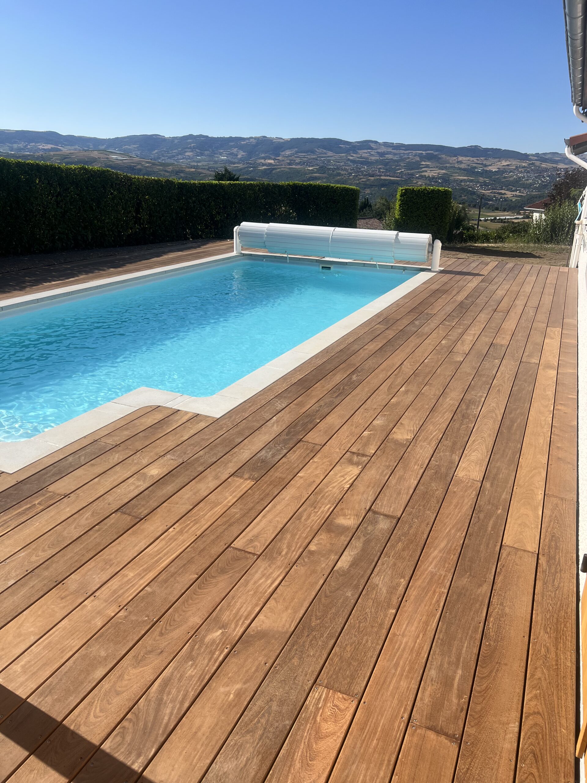 Piscine à débordement avec terrasse en bois exotique et vue panoramique