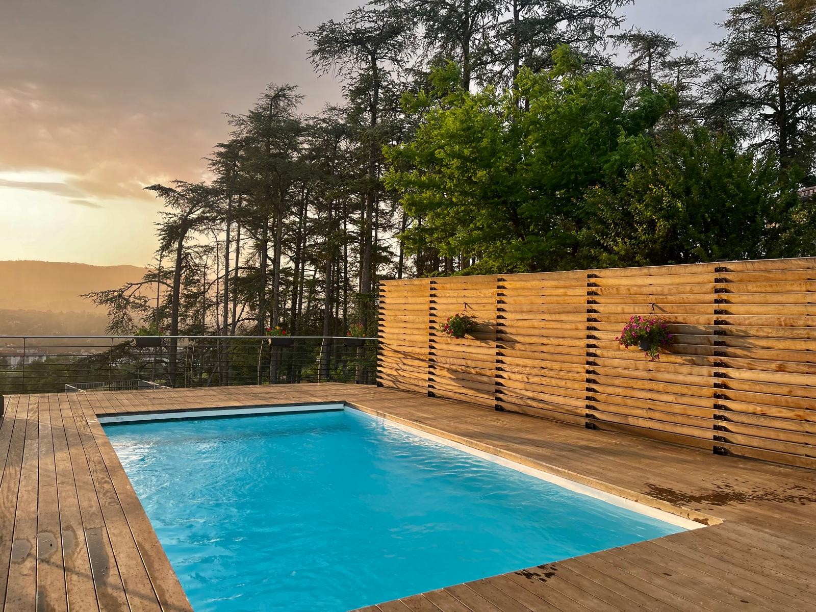 Piscine intégrée à une terrasse en bois avec claustra et vue panoramique